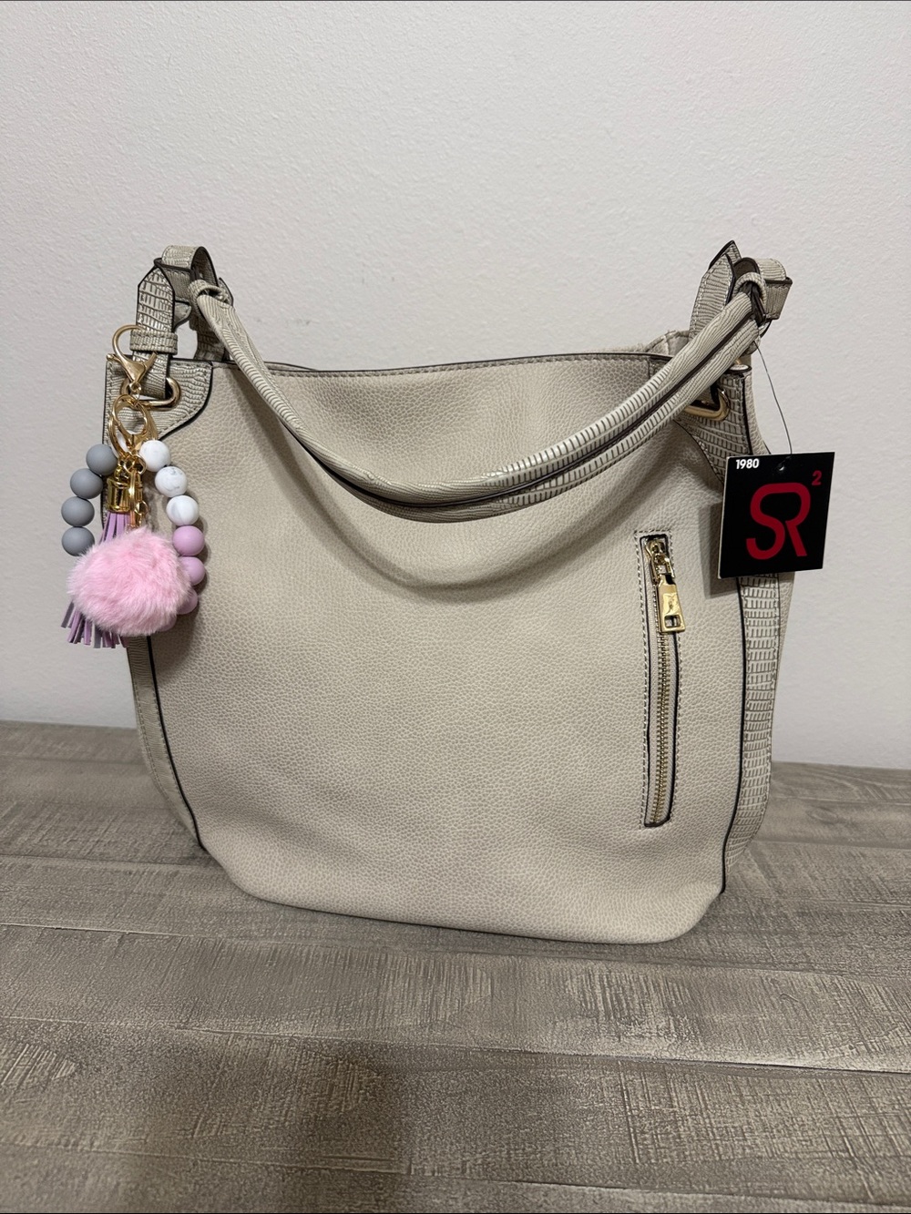 Sondra Roberts Cream Pebbled Shoulder Bag with Pink Pom Charm